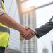 construction-workers-protective-helmets-vests-are-shaking-hands-while-working_35048-654
