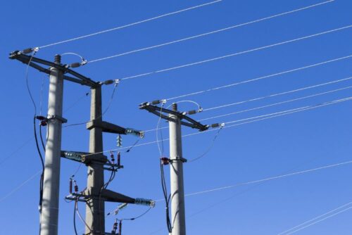 shot-electric-posts-lines-against-blue-background_181624-27509