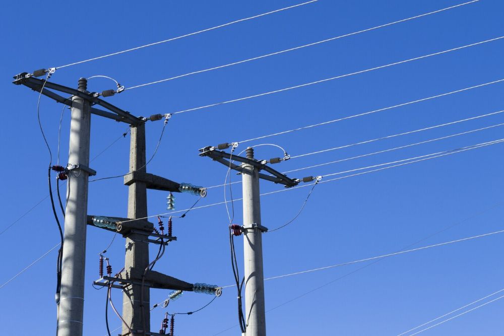 shot-electric-posts-lines-against-blue-background_181624-27509