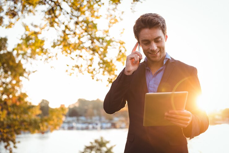 businessman-talking-mobile-phone-while-using-digital-tablet_107420-65921
